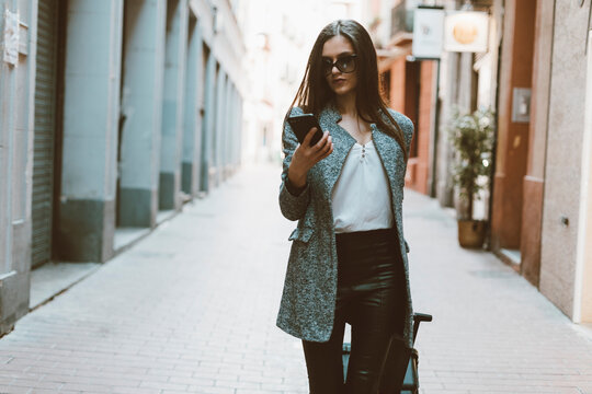Young businesswoman in the city checking cell phone