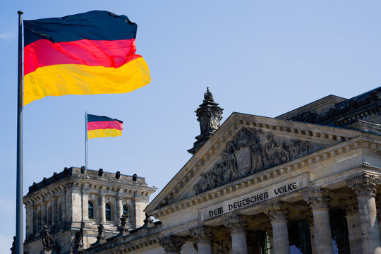 Germany, Berlin, view to upper part of Reichstag building with two German flags