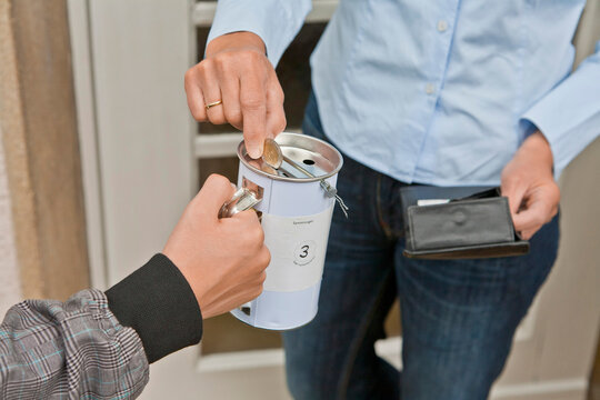 Teenage boy donating money at door