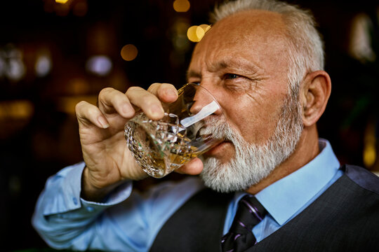 Portrait of elegant senior man drinking from tumbler