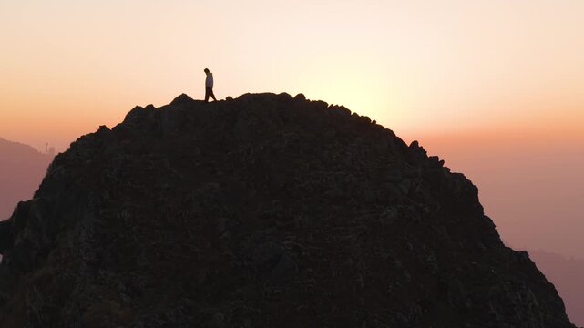 4K drone footage capturing the beauty of a Himalayan sunrise with a boy standing on a mountain ridge.