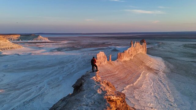a man stands and watches the sunset in Bozzhyra is a tract in the western part of the Ustyurt Plateau on the Mangyshlak Peninsula in the Mangystau Region of Kazakhstan