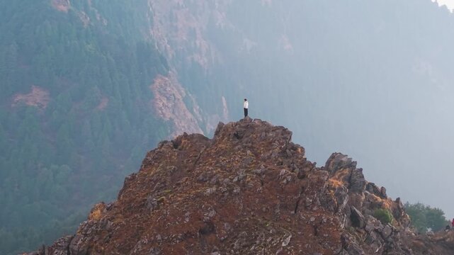 4K drone 360 shot capturing a boy enjoying panoramic sunrise views over the Himalayas in Uttarakhand.