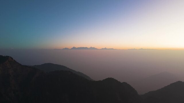 4K aerial view of Trishul, Nanda Devi, and Nanda Kot mountain peaks illuminated by sunrise in Uttarakhand.