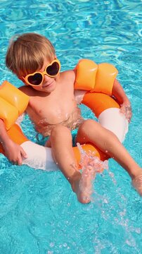 A happy child is having fun on the beach during the summer holidays. Slow motion. Vertical video