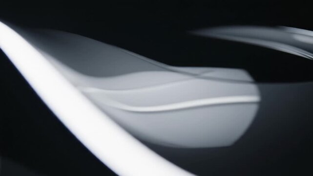Abstract smooth curve light dark wave reflection glossy modern design featuring futuristic white curved object with glowing edges dark background and sleek surface ambient lighting creating