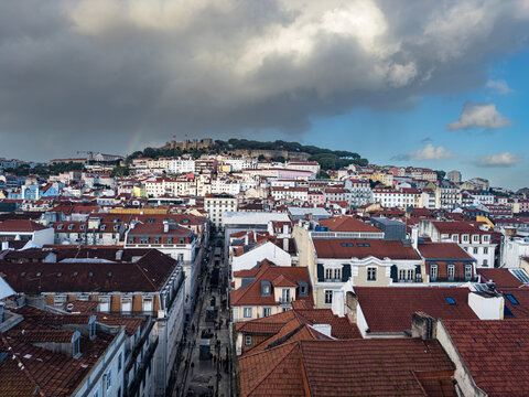 View over the red-tiled roofs of downtown and old town towards the Castelo de Sao Jorge on a hill in Lisbon, Portugal.