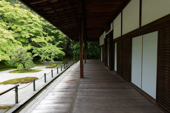 伝統的な木造建築の長い縁側から望む美しい新緑と日本庭園の景観