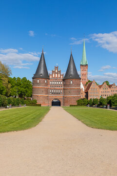 Holstein Gate at L&uuml;beck, Germany, with bell tower of Petrikirche and historic warehouses