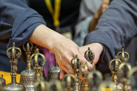 People selecting and arranging Tibetan bronze vajra bell ritual implements