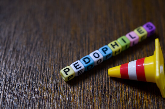 Pedophiles warning concept with letter beads and traffic cone