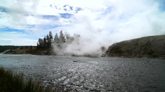 Grand Prismatic Spring largest hot springs steaming pool Mid Geyser Basin Firehole River Wyoming USA Yellowstone National Park nature landscape riverbank Midway Boardwalk sunny blue sky morning static
