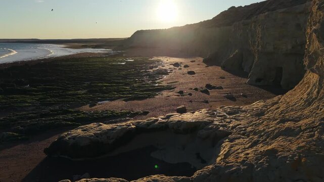 Coastal cliffs near Puerto Madryn Chubut Argentina in Golfo Nuevo display Patagonian sedimentary strata and marine abrasion platforms shaped by wave erosion under Atlantic conditions, forward flyover