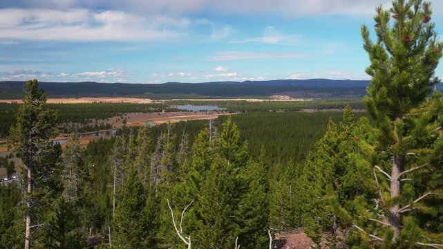 Elevated overlook trail Grand Prismatic Springs lookout Firehole River hot springs steaming pool Mid Geyser Basin Wyoming Yellowstone National Park tourist attraction nature landscape morning pan left