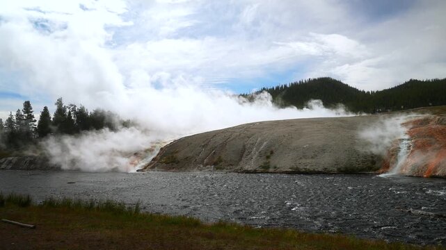 Firehole River Grand Prismatic Spring largest hot springs pool Mid Geyser Basin Wyoming USA Yellowstone National Park nature landscape Midway Boardwalk hiking trail sunny blue sky morning riverbank