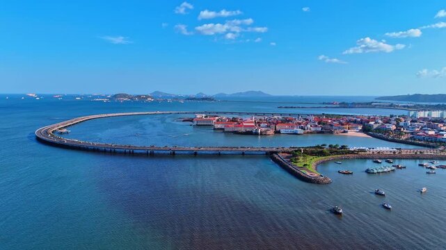 Casco Viejo Panama City Aerial View with Cargo Ships. An aerial view shows Casco Viejo on its peninsula with cargo ships anchored on the bay horizon.