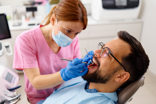 Professional dentist examining patient teeth in modern dental office