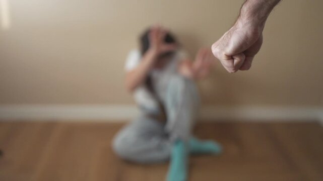 Person sitting on the floor with their hand up. A child is threatening to punch a girl with a fist. A girl is afraid of danger. An individual seated lifestyle on the ground with their hand raised.