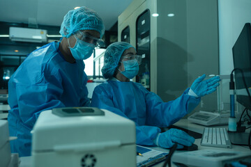 Medical or research scientist or doctor using looking at a test tube of clear solution in a lab or...