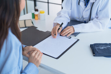 Doctor explaining treatment plan and obtaining informed consent while patient signing consent form...