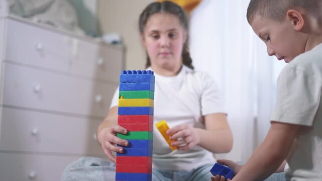 Two children playing with blocks. A group of children are blocks assembling a construction. A group of kids play with toys. Two kids stacking lifestyle.