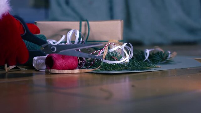 Hands with Christmas gift wrapping ribbon and string green background