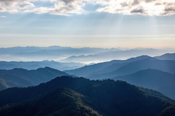 Fototapeta premium The Mountains Bathed in Soft Morning Light with Misty Layered Blue Ridges
