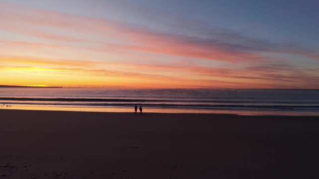Drone Dolly In of Sunrise Over Atlantic Ocean with People Silhouettes in Puerto Madryn Patagonia
