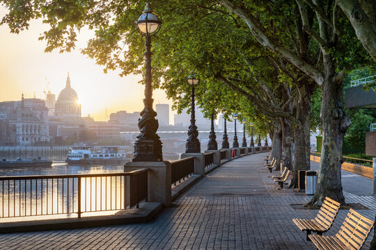 The Southbank in London, England, with view of the City skyline during a golden summer sunrise without people