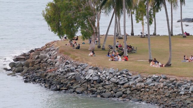 People Relaxing on a Grassy Waterfront Point in Port Douglas Australia