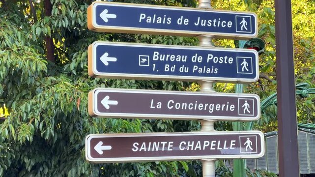 La Conciergerie, post office, Sainte-Chapelle and courthouse direction signs in a street of Paris, France on a sunny day