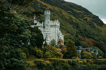 Historic Kylemore Abbey castle and lake surrounded by green forest in Connemara, Ireland © Muñe