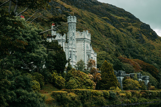 Historic Kylemore Abbey castle and lake surrounded by green forest in Connemara, Ireland
