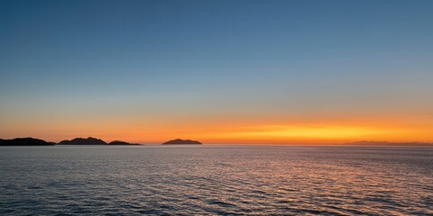 Obraz premium The Ocean at Sunset with Vibrant Horizon and Distant Silhouetted Islands