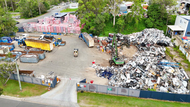 Aerial View of Industrial Scrapyard with Heavy Machinery and Metal Piles