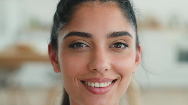 Happy smiling Arabian Indian woman portrait showing healthy white teeth joyful cheerful positive emotion carefree satisfied female beauty dental oral health attractive ethnic girl face make up indoors