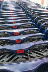 Fototapeta premium Row of blue plastic shopping carts in a store. Perspective view of empty shopping carts waiting for customers in a hypermarket