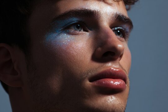 Trend male cropped close up with sky blue glowing eye and nose highlight for makeup editorial and beauty banner