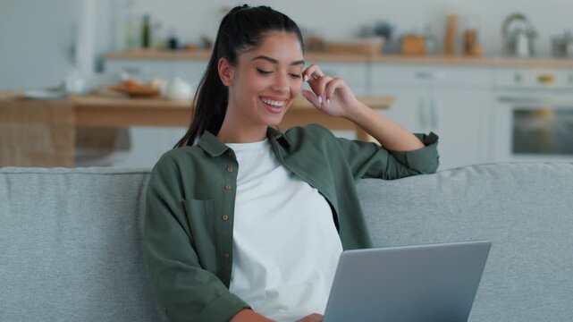 Happy smiling Arabian Indian woman use laptop celebrating win victory at home couch success excited champion freelancer student female working studying remote browsing online shopping discount indoor