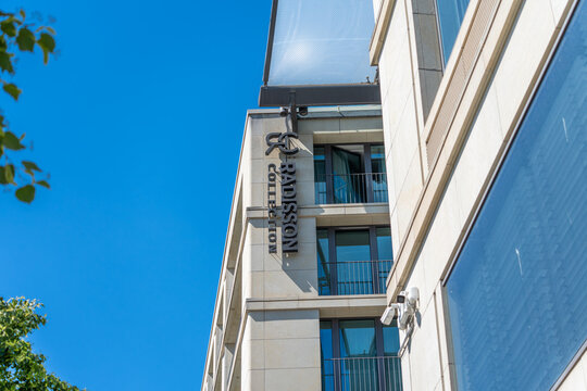 Germany, Berlin May 25, 2026 The Radisson Collection sign rises on a bright modern hotel facade. Blue sky, balconies, glass and leaves create a clean urban travel image.