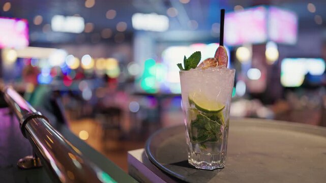 Highdefinition footage showcasing refreshing mojito amidst luxurious nightlife and colorful signage