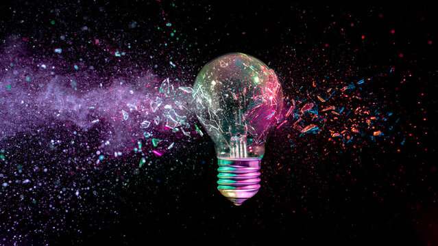 Exploding light bulb shattering black background