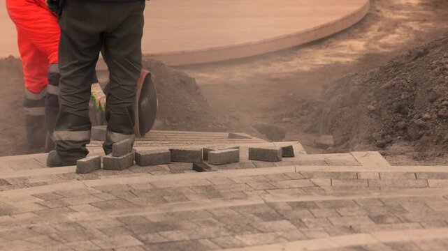 Closeup road building process cutting stone and laying city pavement bricks