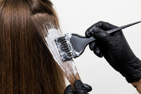 Close-Up of Stylist Wearing Black Gloves Applying Hair Dye Cream with Brush