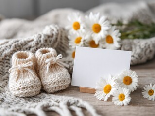 Fototapeta premium Baby shoes with daisies and blank card