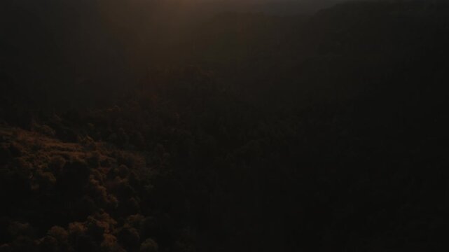 Nevado de Colima volcano at sunset behind distant mountains in aerial establishing shot