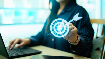 Business target and success concept with glowing dartboard icon.Professional women holding virtual goal with arrow hitting the center for marketing strategy, achievement and corporate growth vision © Zerofukuman