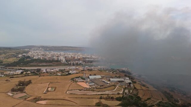 Malta, aerial footage shows toxic smoke from the Magħtab landfill fire drifting toward Qawra, Buġibba and St Paul&rsquo;s Bay, creating a public safety hazard over the Mediterranean coast on May 6th, 2026.