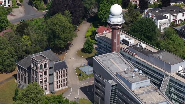 High angle aerial view of the royal netherlands meteorological institute, knmi, campus in de bilt showing the iconic weather radar tower and surrounding modern and classic office buildings