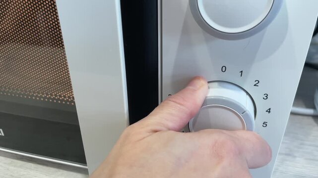 Adjusting oven settings carefully. Meticulous selection of oven modes for perfect baking results. Carefully rotating controls on stainless steel panel for accurate cooking and timed baking
